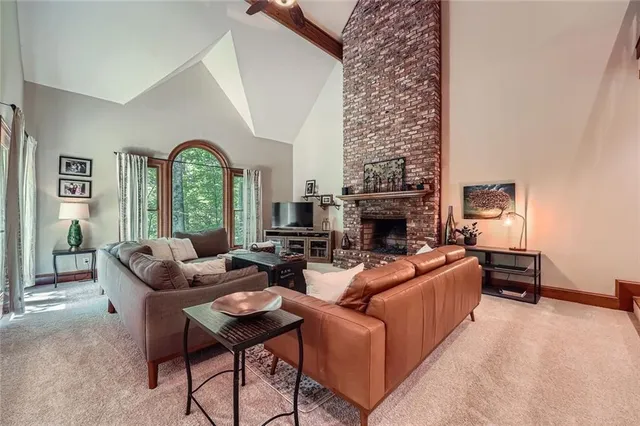 a living room with furniture large window and a fireplace
