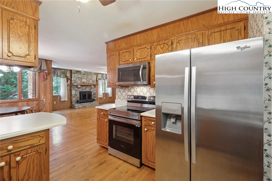 2076 Jay Clark Road Morganton, NC 28655 - Photo 21 of 36 a kitchen with stainless steel appliances granite countertop a refrigerator a stove and a sink with wooden floors
