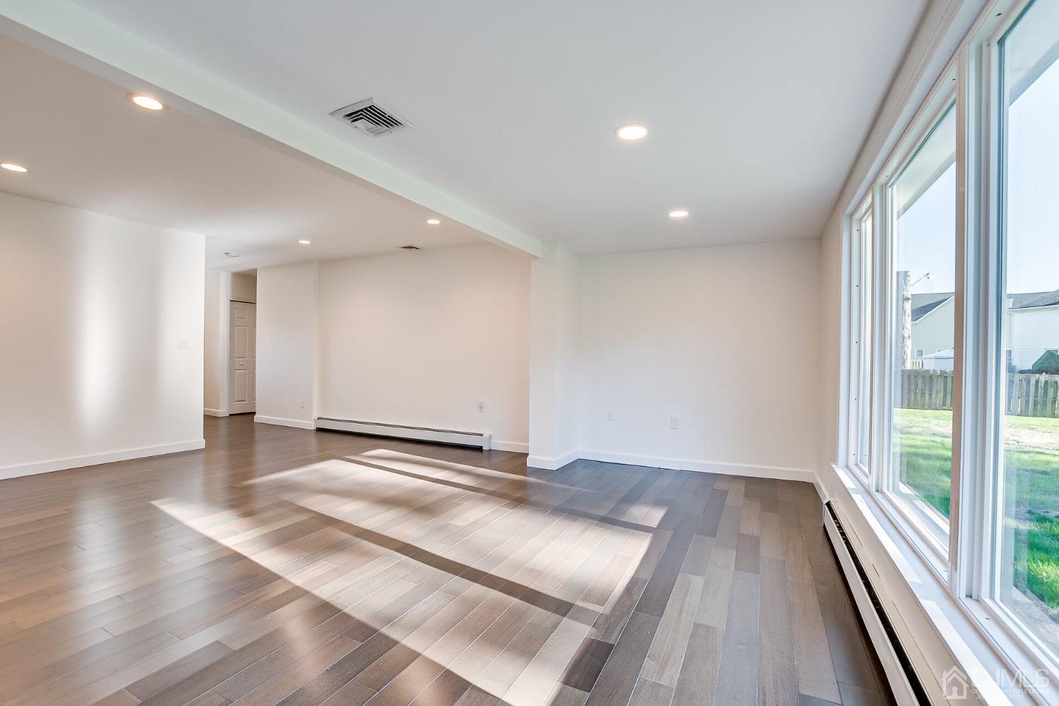 38 New Brooklyn Road Edison, NJ 08817 - Photo 13 of 39 a view of an empty room with wooden floor and a window