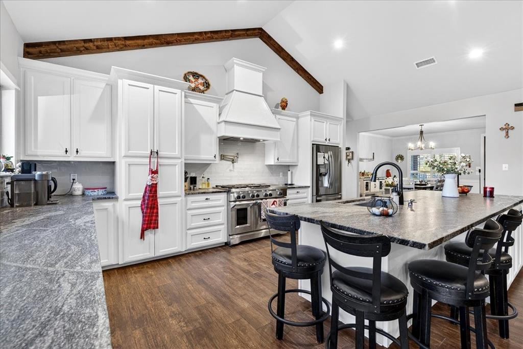 323 County Road 2103 Canton, TX 75103 - Photo 7 of 23 a kitchen with stainless steel appliances kitchen island granite countertop a table chairs stove and white cabinets