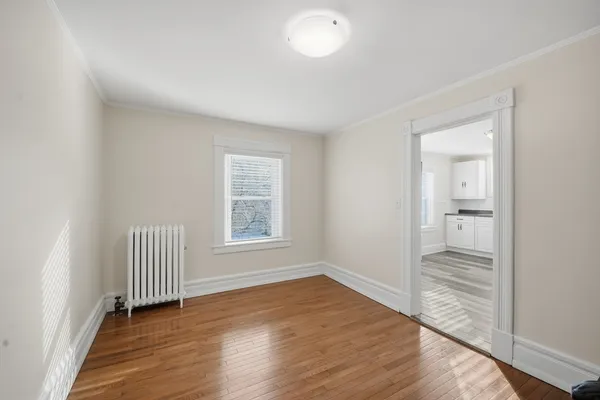 an empty room with wooden floor and a window