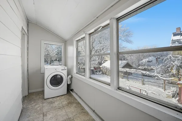 a utility room with wooden floor and window