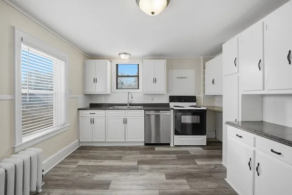 a kitchen with granite countertop white cabinets and white appliances