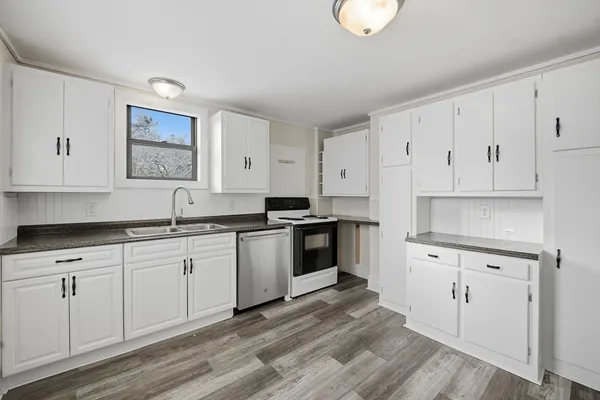 a kitchen with granite countertop white cabinets and white appliances