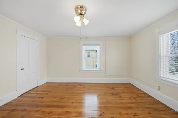 a view of a room with wooden floor and window