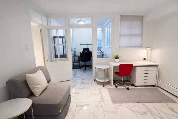 a living room with furniture gym equipment and a window