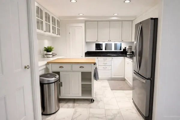 a kitchen with stainless steel appliances granite countertop a stove a refrigerator and a cabinets