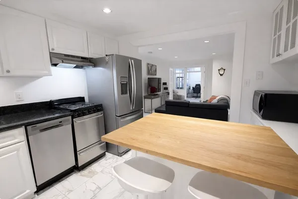 a kitchen with stainless steel appliances a refrigerator sink and stove
