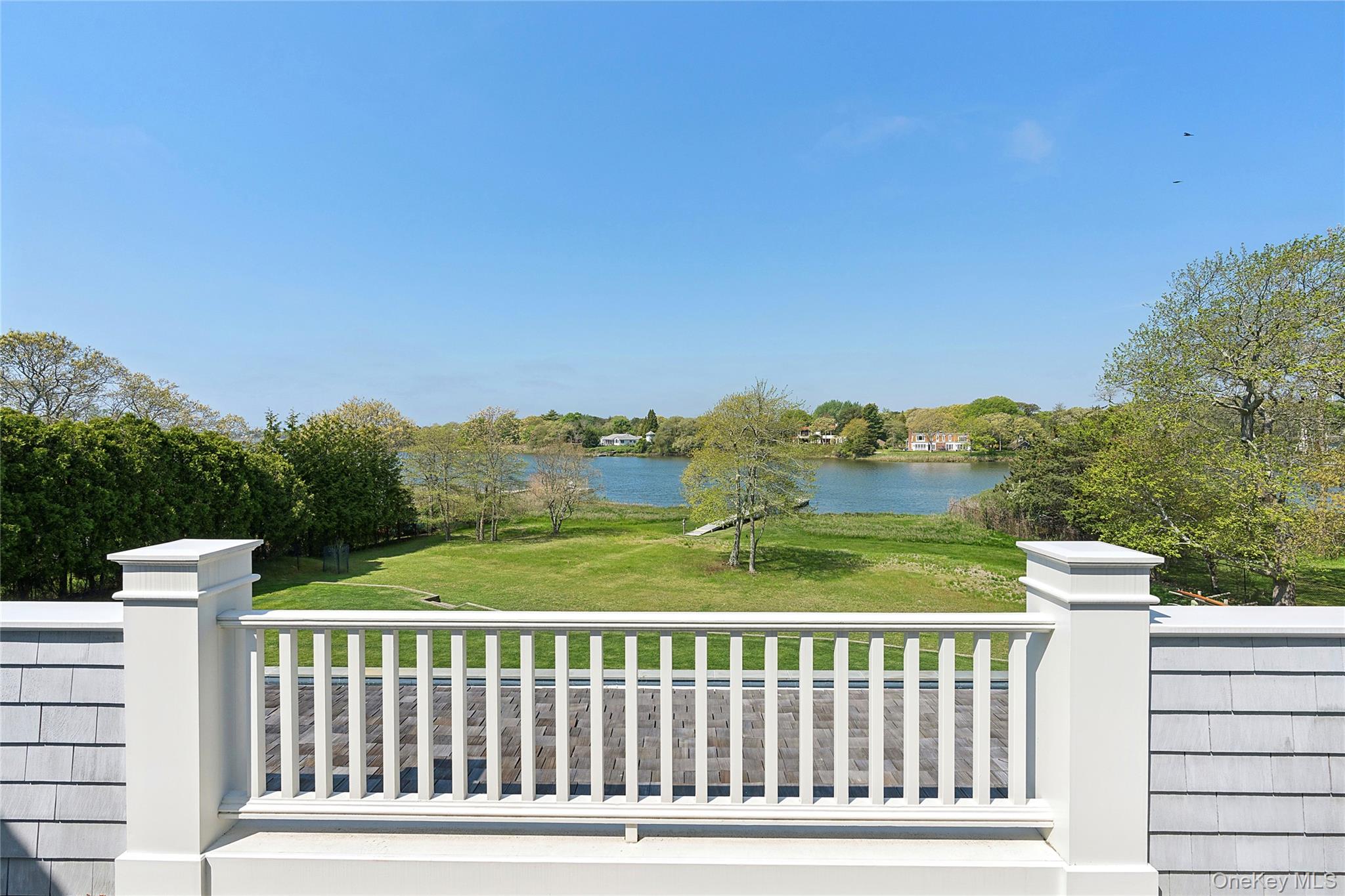 43 Old Main Road Quogue, NY 11959 - Photo 22 of 28 a view of a balcony with wooden floor & fence