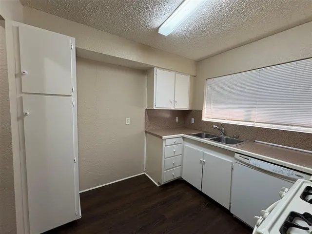 a kitchen with a sink cabinets stainless steel appliances and a window