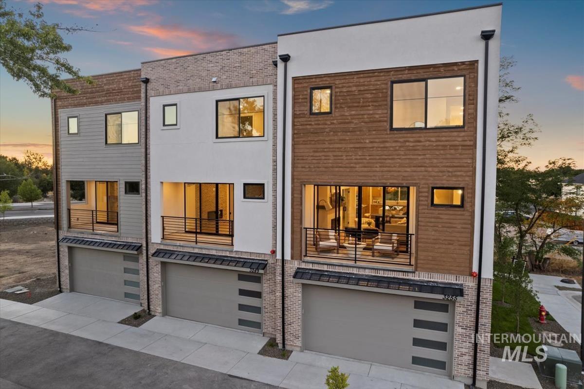 3243 West Moore Street Boise, ID 83702 - Photo 32 of 38 Back of house at dusk featuring a garage, a balcony, and concrete driveway