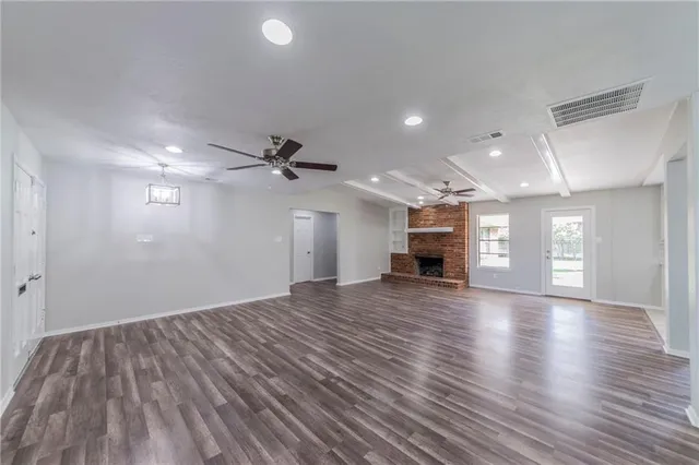 a view of empty room with wooden floor and windows