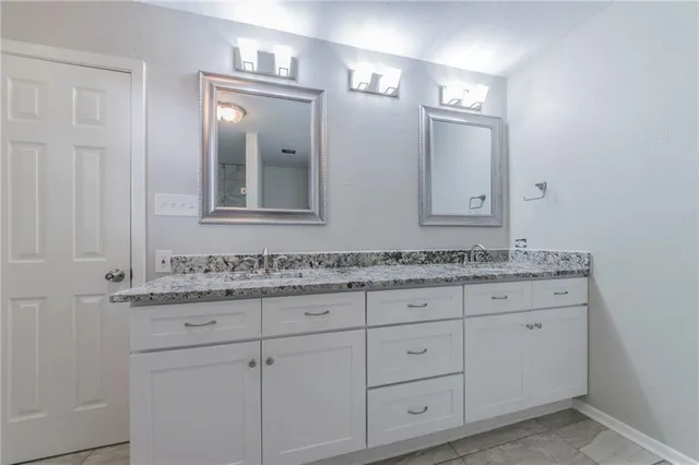 a bathroom with a granite countertop sink vanity and mirror