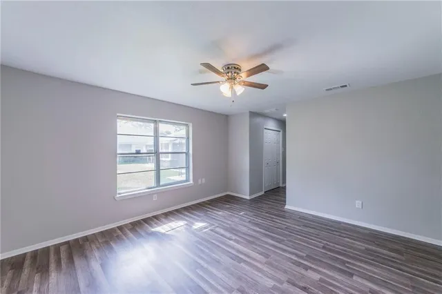an empty room with wooden floor and a window
