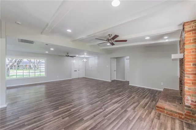 a view of an empty room and window and wooden floor