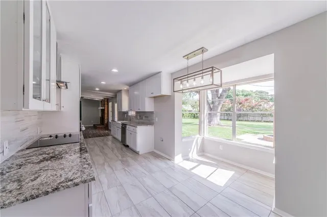 a kitchen with a large window appliances and cabinets