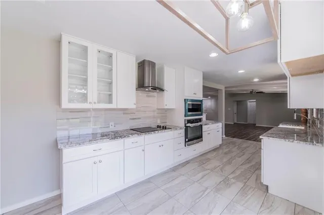 a large kitchen with kitchen island a sink stainless steel appliances and cabinets