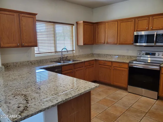 a kitchen with stainless steel appliances granite countertop a sink stove and microwave