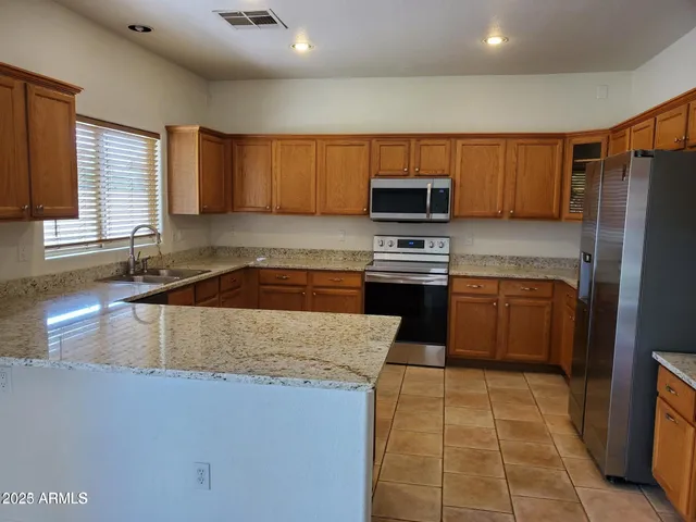 a kitchen with stainless steel appliances granite countertop a sink counter space cabinets and a large window