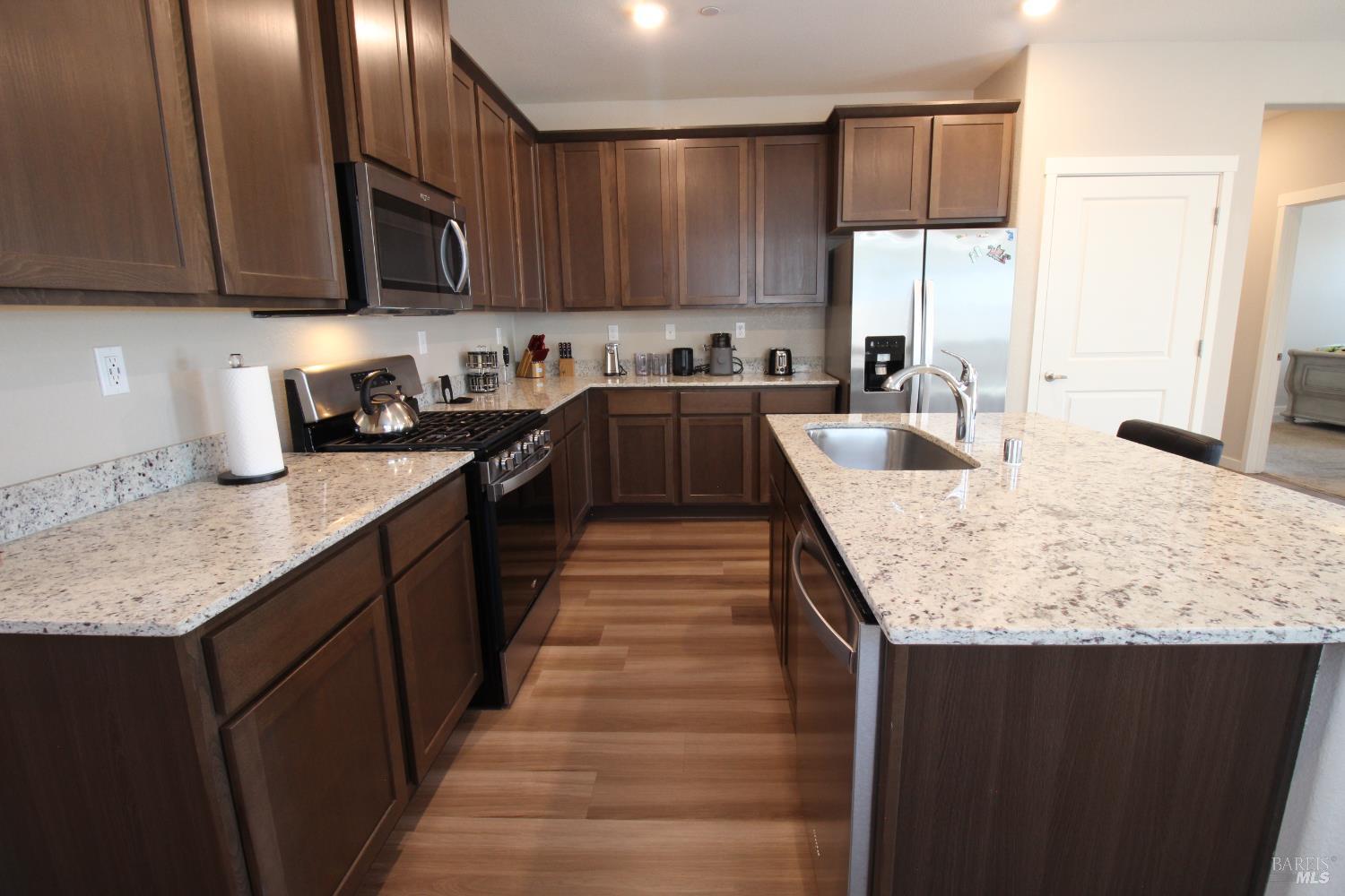 2283 Revival Lane Rio Vista, CA 94571 - Photo 6 of 44 a kitchen with kitchen island granite countertop a sink stove and cabinets