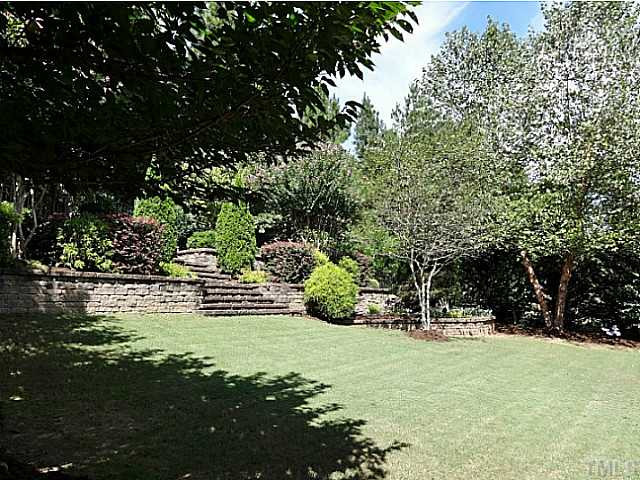 3212 Queensland Road Raleigh, NC 27614 - Photo 23 of 25 This is a magnificent well landscaped private yard. It boast beautiful trees and shrubs for all seasons. The area has electrical landscaping lights on a timer. The terraced brick wall and steps lead to a gate so you can feed the deer or birds. Back Yard