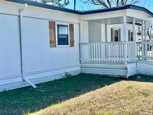 a view of a house with a small yard and wooden fence