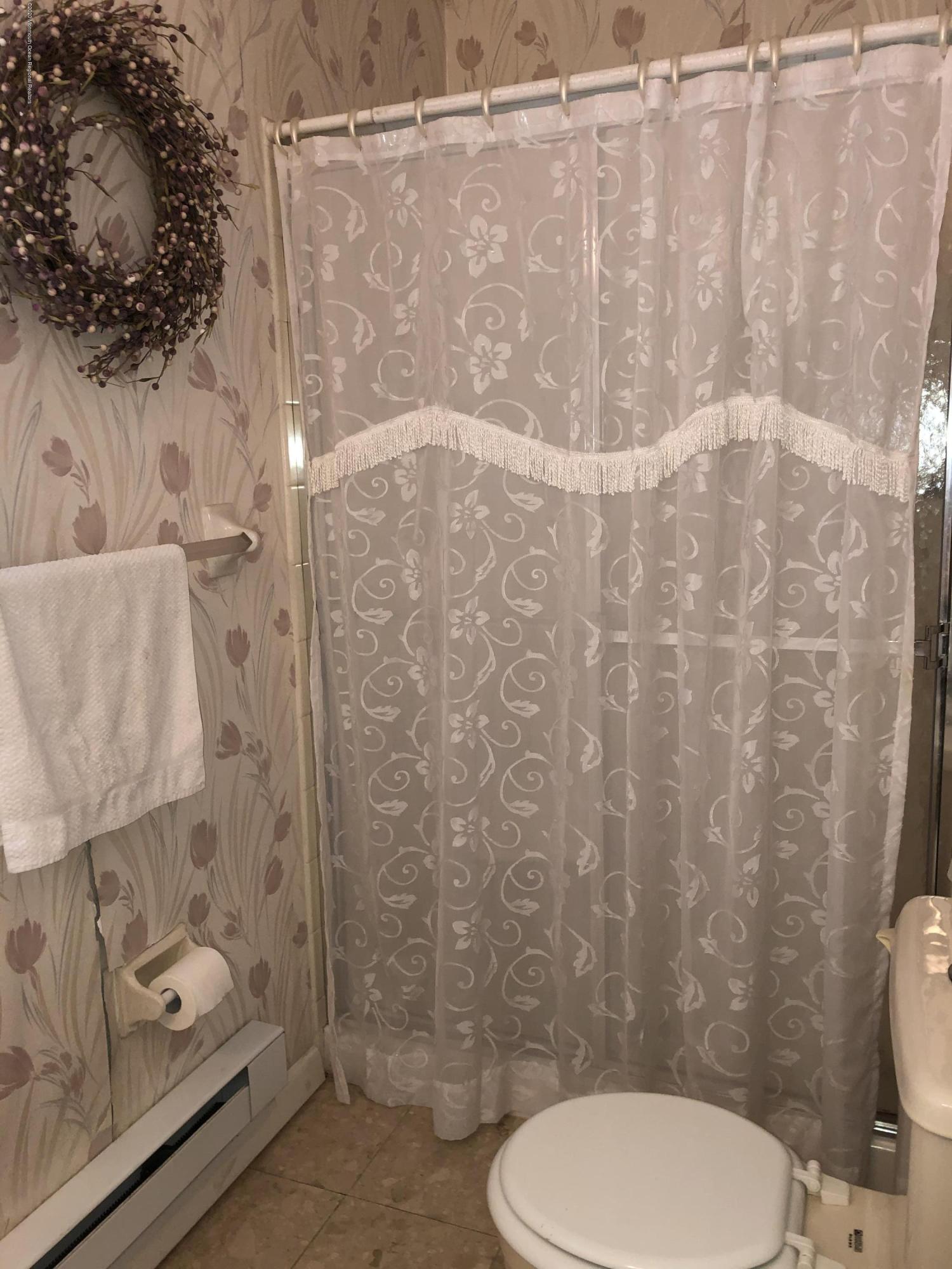 22 Abbey Road Brick, NJ 08723 - Photo 19 of 22 a white toilet sitting next to a shower curtain