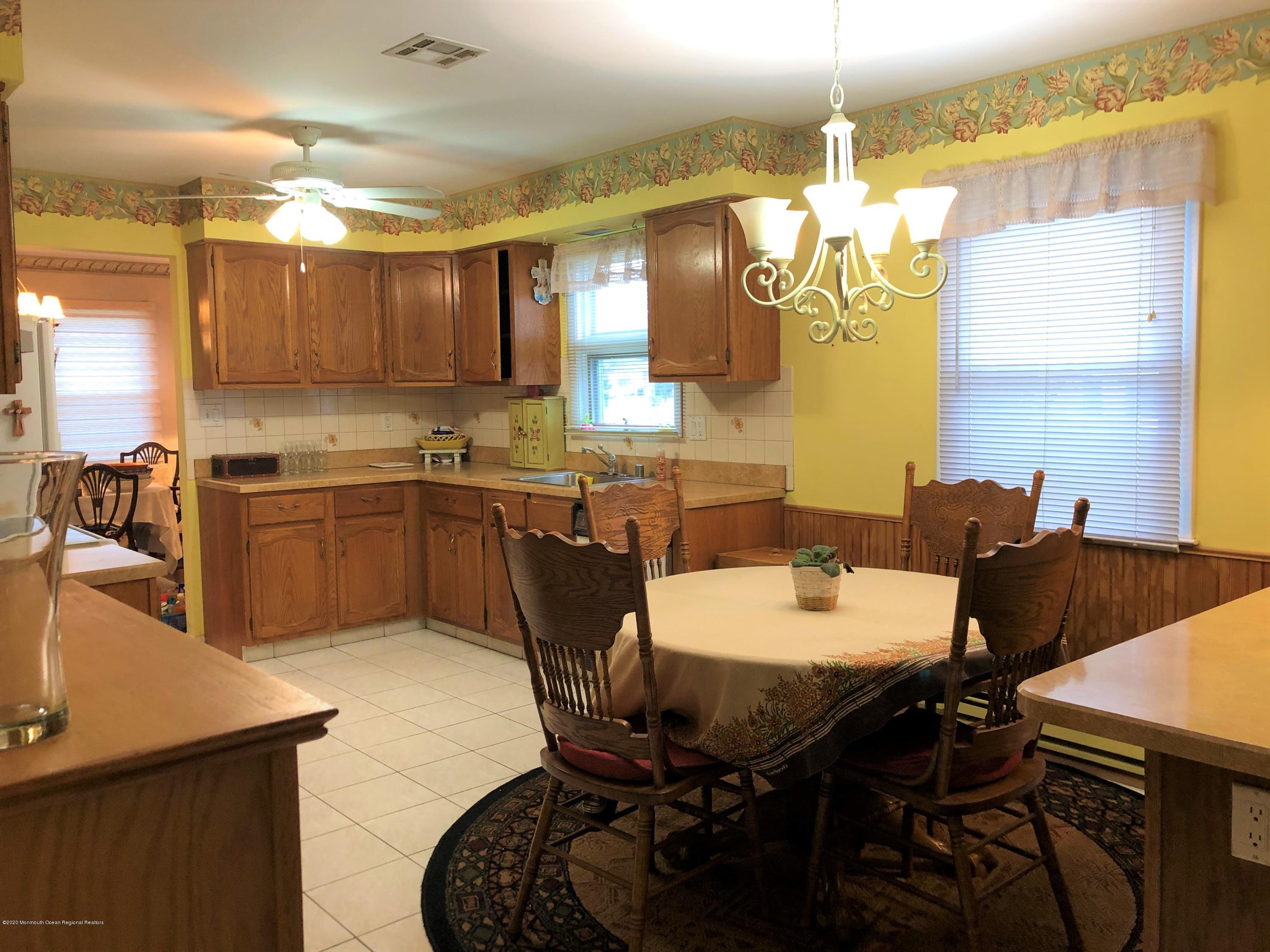 22 Abbey Road Brick, NJ 08723 - Photo 8 of 22 a kitchen with a dining table chairs and sink