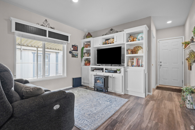 150 West 7500th South, Unit 13 Midvale, UT 84047 - Photo 5 of 32 Living area featuring built-in white cabinetry with open shelving, wood-finish flooring, and a multi-pane window