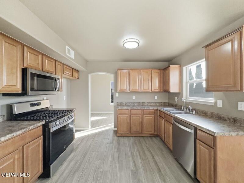533 Flanagan Place El Paso, TX 79928 - Photo 18 of 52 a kitchen with stainless steel appliances granite countertop wooden cabinets a sink dishwasher a stove and a refrigerator with wooden floor