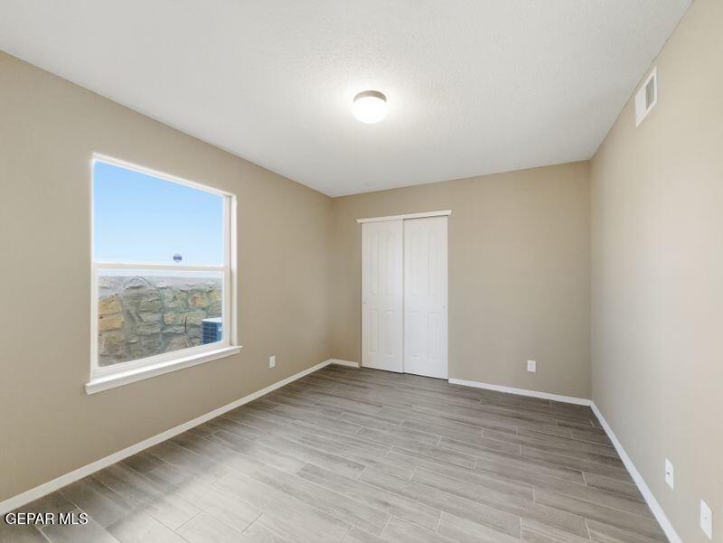 533 Flanagan Place El Paso, TX 79928 - Photo 9 of 52 an empty room with wooden floor and windows