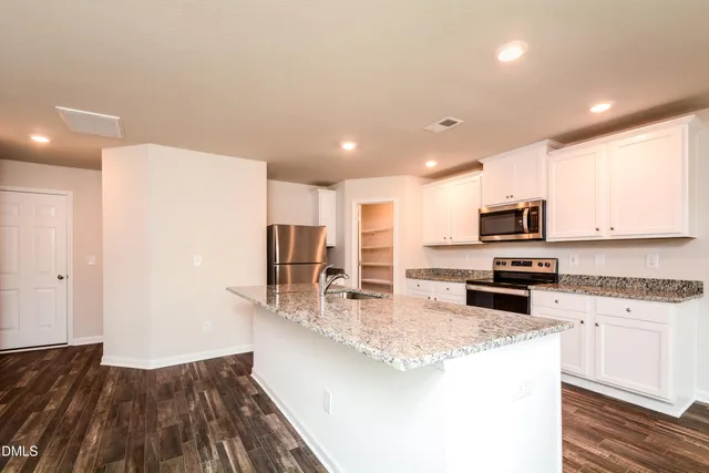 a kitchen with stainless steel appliances granite countertop a sink refrigerator and microwave