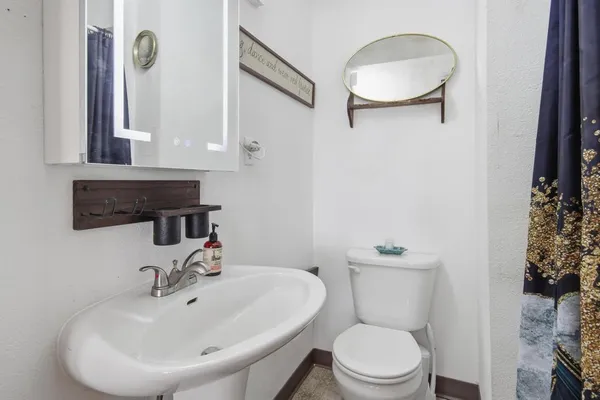 a bathroom with a sink a toilet and mirror