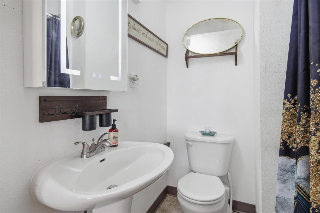 126 4th Street Tuscola, TX 79562 - Photo 13 of 31 a bathroom with a sink a toilet and mirror