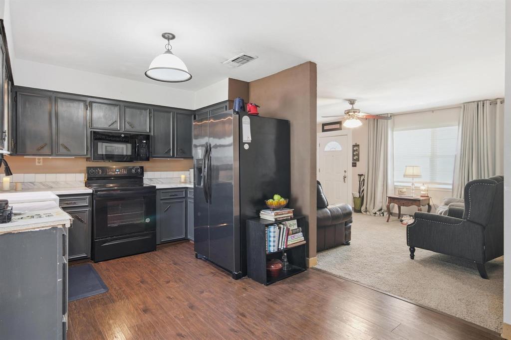 126 4th Street Tuscola, TX 79562 - Photo 15 of 31 a kitchen with stainless steel appliances kitchen island granite countertop a refrigerator a stove top oven a sink and dishwasher