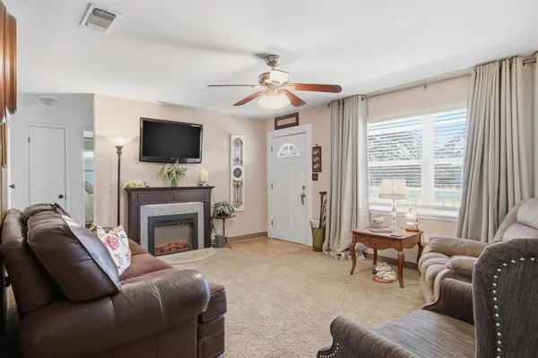 a living room with furniture a flat screen tv and a fireplace