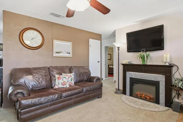 a living room with furniture a flat screen tv and a fireplace