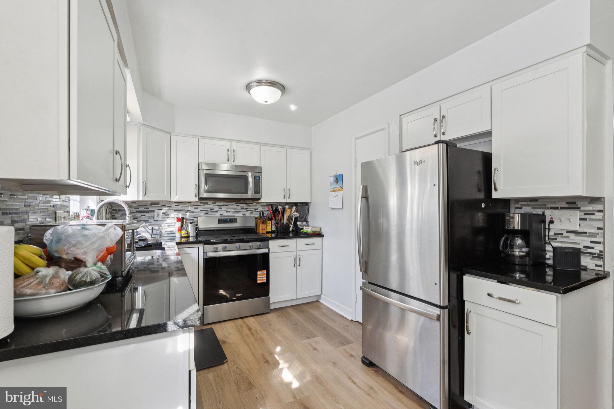 3978 Stevenson Street Philadelphia, PA 19114 - Photo 12 of 25 a kitchen with stainless steel appliances a refrigerator a stove a microwave and cabinets