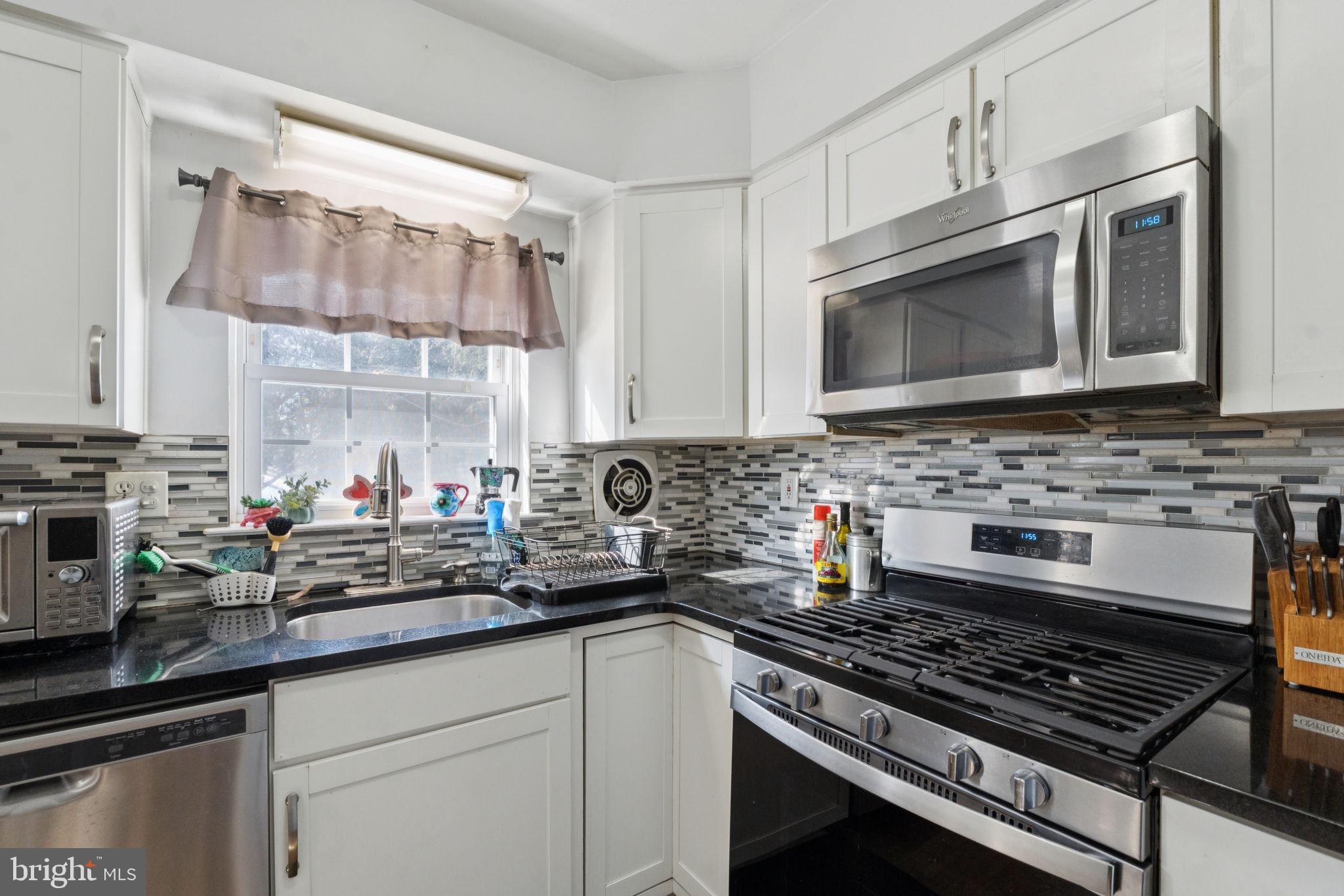 3978 Stevenson Street Philadelphia, PA 19114 - Photo 14 of 25 a kitchen with stainless steel appliances a stove sink and cabinets