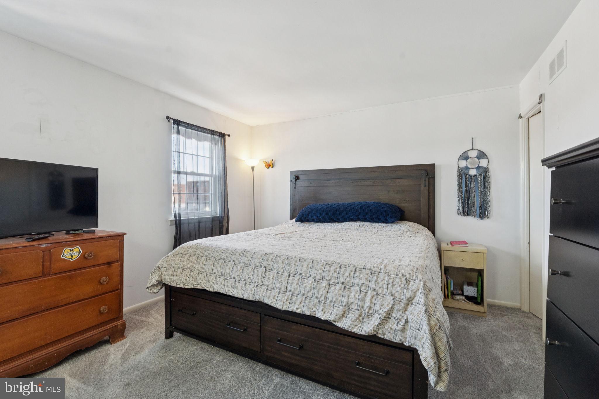 3978 Stevenson Street Philadelphia, PA 19114 - Photo 23 of 25 a bedroom with a bed and a flat tv screen on dresser