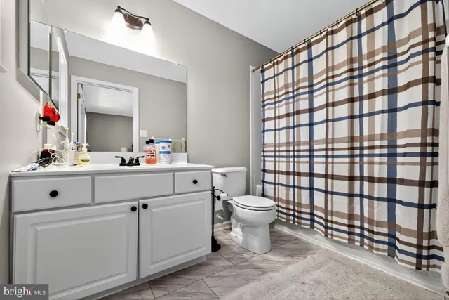 a bathroom with a sink vanity mirror and toilet