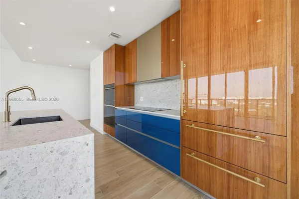 a kitchen with stainless steel appliances granite countertop a sink and a refrigerator