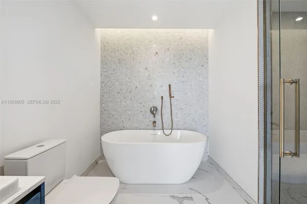 a white bath tub sitting next to a white toilet