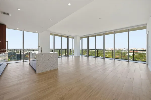 a view of empty room with wooden floor and windows