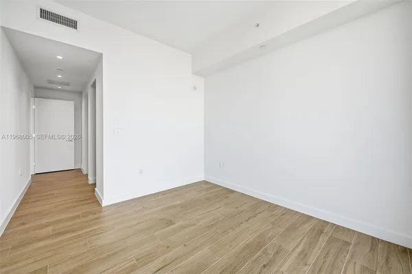 a view of a room with wooden floor and windows