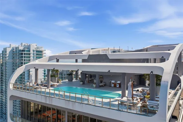 a swimming pool with outdoor seating and city view