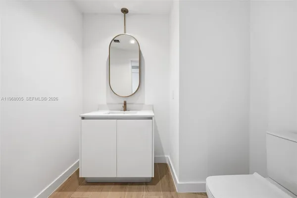 a bathroom with a sink mirror and toilet