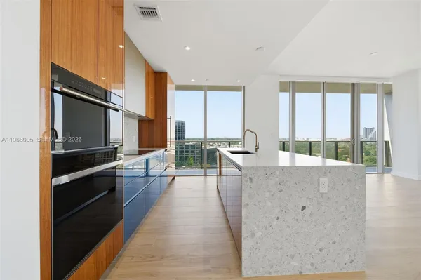 a large kitchen with kitchen island granite countertop a large counter top stainless steel appliances and windows