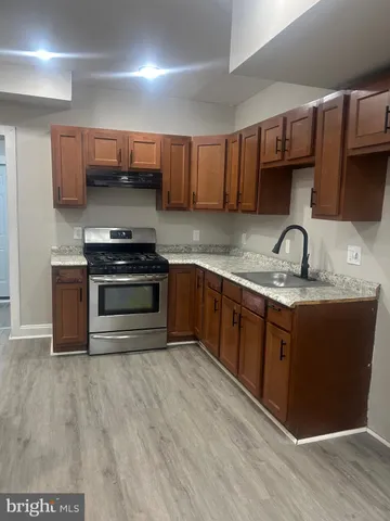 a kitchen with stainless steel appliances granite countertop a sink stove and cabinets