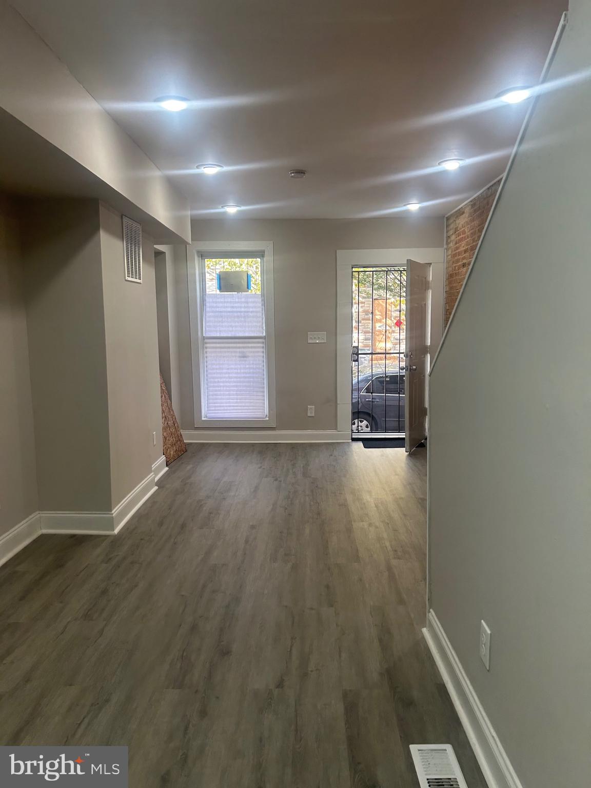 1823 Ramsay Street Baltimore, MD 21223 - Photo 4 of 13 an empty room with wooden floor and windows